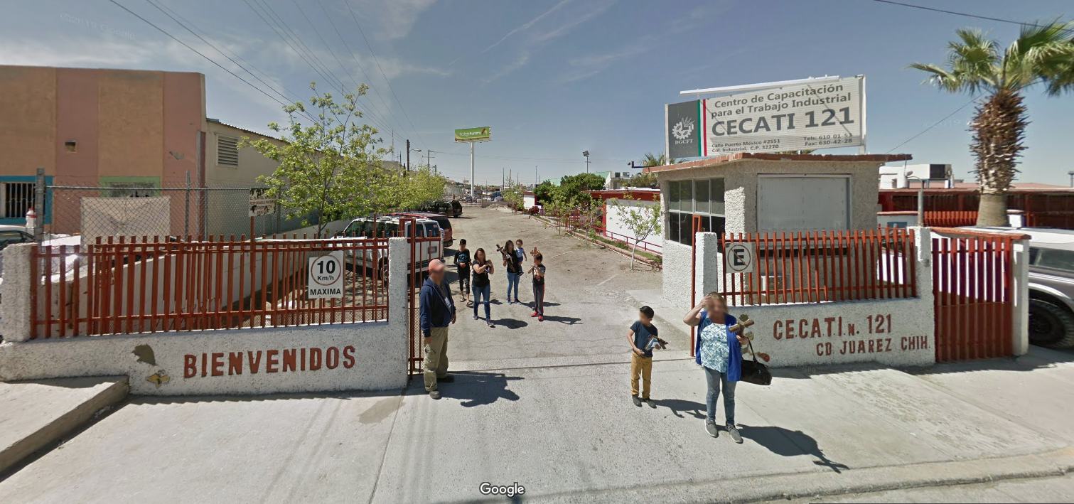 Fotografía en la que se muestra la entrada del plantel conformada por muros de color blanco con rejas de color rojo. Entre los muros, hay un espacio abierto que permite el acceso. El muro del lado izquierdo dice en letras rojas BIENVENIDOS y en el muro del lado derecho dice CECATI NÚMERO 121, CIUDAD JUAREZ CHIHUAHUA.